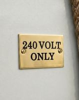 The Solid Brass Plaque With Black Lettering Label that Reads  "240 volt Only" Shown Close up - Digital Illustration 