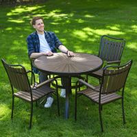 The Solis Round 4-Seater Outdoor Dining Set in Coffee With a Man Sat at the Table Relaxing