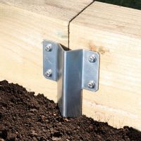 The Stainless Steel Railway Sleeper Straight Inline Spikes - Single in the Ground next to a Railway Sleeper Planter