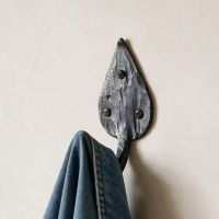 The Steel Leaf Shaped Hook Shown Close Up on a Cream Coloured Wall - Digital Illustration 