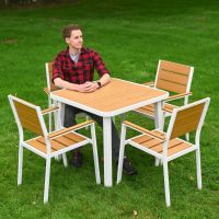 The Strata Slatted 4-Seater Outdoor Dining Set with a Smiling Man Sat at the Table for Scale