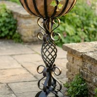 The "Stretton" Victorian Wrought Iron Basket Planter Stand in a Black Finish Showing a Close up of the Detailed and Decorative Spiral Scrollwork on the Base - Digital Illustration 