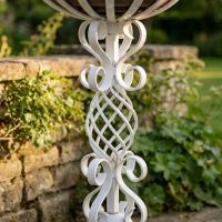 The "Stretton" Victorian Wrought Iron Basket Planter Stand in a White Finish Showing a Close up of the Detailed and Decorative Spiral Scrollwork on the Base - Digital Illustration 