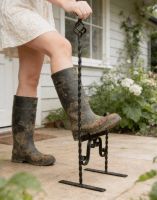The Thomason Tudor Styled Free Standing Boot Scraper Positioned Outside a House Being used by a Lady The Thomason Tudor Styled Free Standing Boot Scraper Positioned Outside a House Being used by a Lady