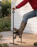 The Thomason Tudor Styled Free Standing Boot Scraper Positioned Outside a House Being used by a Man The Thomason Tudor Styled Free Standing Boot Scraper Positioned Outside a House Being used by a Man