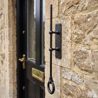 The Traditional Black Iron Mechanical Bell Pull Handle shown detached on the Front of a Home - Digital Illustration The Traditional Black Iron Mechanical Bell Pull Handle shown detached on the Front of a Home - Digital Illustration