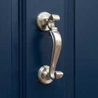 The Traditional Doctor"s Door Knocker in  Satin Stainless Steel Shown Close up on a Blue Front Door - Digital Illustration