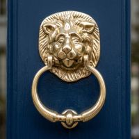 The Traditional Polished Brass Lion Door Knocker on a Blue Front Door Shown Close up - Digital Illustration 