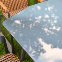 The Tribeca Weave 8-Piece Patio Dining Set Showing a Close up of the Glass Table Top