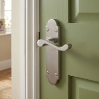 The Victorian Scroll Latch Arched Door Handle in Polished Chrome on an Olive Green Door in a Family Home - Digital Illustration