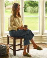 Person Sat on Traditional and Rustic Cross Hatch Brown Leather and Wood Stool for Scale