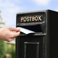 Letter Opening in Use on Traditional Black & Gold Post Box and Stand