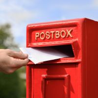 Letter Opening in Use on Traditional Red & Gold Post Box and Stand