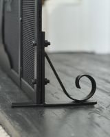 Close up of ornate scrollwork leg detail on tree of life fire screen