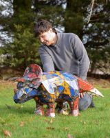 "Trike’ the Triceratops Upcycled Oil Drum Garden Sculpture with man crouching down next to sculpture for scale "Trike’ the Triceratops Upcycled Oil Drum Garden Sculpture with man crouching down next to sculpture for scale