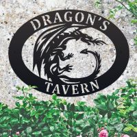 Tribal Dragon Iron Oval House Sign in situ in a Stone Wall Tribal Dragon Iron Oval House Sign in situ in a Stone Wall