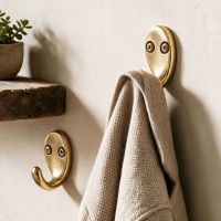 Two Aged Brass Single Pronged Coat Hooks on a Wall in a Entrance Hall - Digital Illustration 