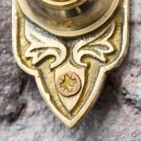 Close up of polished brass embellishment and screw hole  Close up of polished brass embellishment and screw hole
