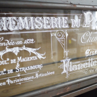 Close up of White French Text on Glass Front  Close up of White French Text on Glass Front