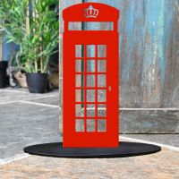 Red Telephone Box Iron Door Stop Next to a Rustic Blue Door