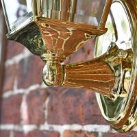 Close-up of the Polished Brass Bracket on the Wall Light Close-up of the Polished Brass Bracket on the Wall Light