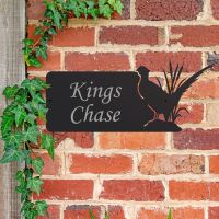 Pheasant Iron House Name Sign Mounted o a Brick Wall
