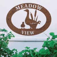 Goose & Gosling Iron Oval House Sign on a White Wall Goose & Gosling Iron Oval House Sign on a White Wall