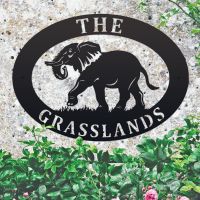 Elephant Iron Oval House Sign on a Stone Wall Elephant Iron Oval House Sign on a Stone Wall