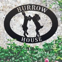 Boxing Hares Iron Oval House Sign on a Stone Wall