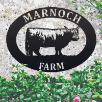 Highland Cow Iron Oval House Sign on a Stone Wall Highland Cow Iron Oval House Sign on a Stone Wall