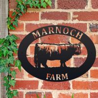 Highland Cow Iron Oval House Sign on a Brick Wall Highland Cow Iron Oval House Sign on a Brick Wall