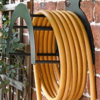 Side View of the Wall Mounted Boxing Hares Iron Hose Holder Mounted to a Brick Wall Side View of the Wall Mounted Boxing Hares Iron Hose Holder Mounted to a Brick Wall