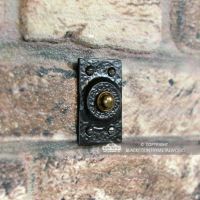 Black Traditional Rectangular Door Bell Push in Situ on a Brick Wall