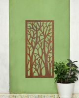 "Rustic Autumnal Trees Garden Wall Art" mounted on a green wall next to house plant