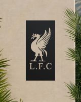 Black "Liver Bird Wall Art" on a beige garden wall surrounded by palm leaves Black "Liver Bird Wall Art" on a beige garden wall surrounded by palm leaves