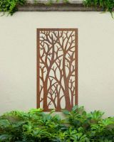 "Rustic Autumnal Trees Garden Wall Art" mounted onto a garden wall amongst plants 