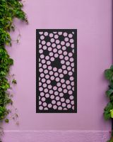 Black "Honeycomb Pattern Wall Art" mounted on a purple garden wall 