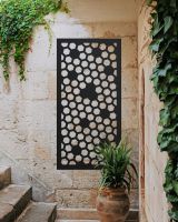 Black "Honeycomb Pattern Wall Art" on brick wall within an outdoor stairwell 