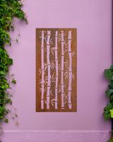 Rust Finish "Bamboo Garden Wall Art" mounted on a purple garden wall with creeping plants Rust Finish "Bamboo Garden Wall Art" mounted on a purple garden wall with creeping plants