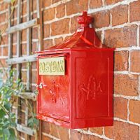 View of the Side of the Red "The Suffolk" Post Box Mounted on a Brick Wall View of the Side of the Red "The Suffolk" Post Box Mounted on a Brick Wall
