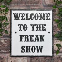 "Welcome To The Freak Show" Cast Iron Sign on a Brick wall Outside "Welcome To The Freak Show" Cast Iron Sign on a Brick wall Outside