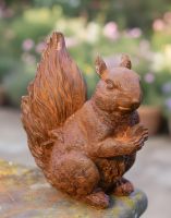 Digital illustration of Rustic Cast Iron "Nutty" Squirrel Miniature Garden Sculpture on a garden wall
