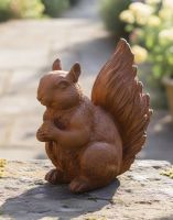 Digital illustration of Rustic Cast Iron "Nutty" Squirrel Miniature Garden Sculpture on garden wall
