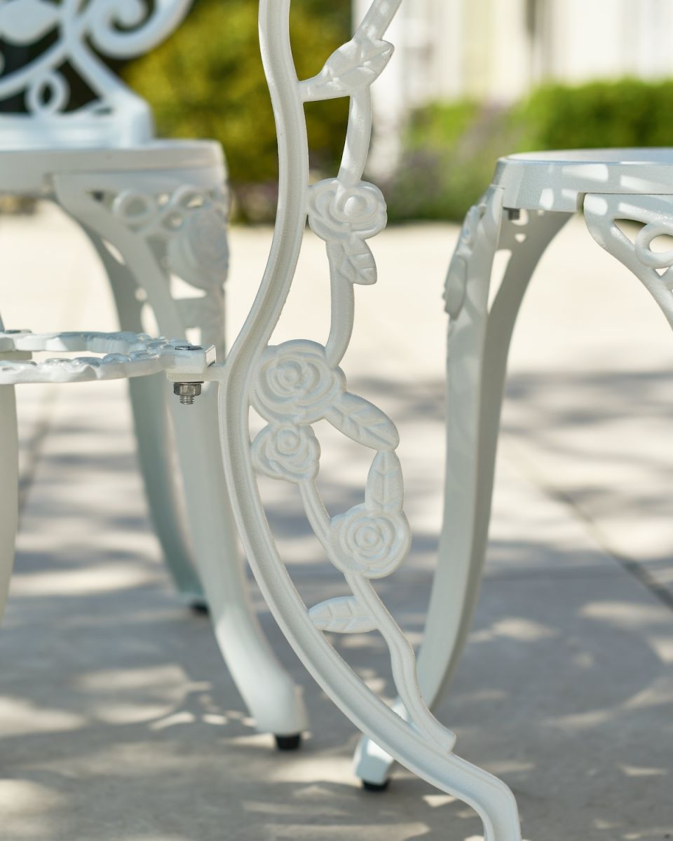 Close up of floral table leg detail on white garden furniture set