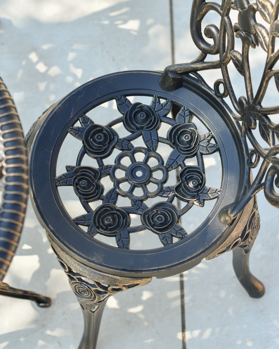Close up of floral detailing on chair seat on ornate two seater bistro set