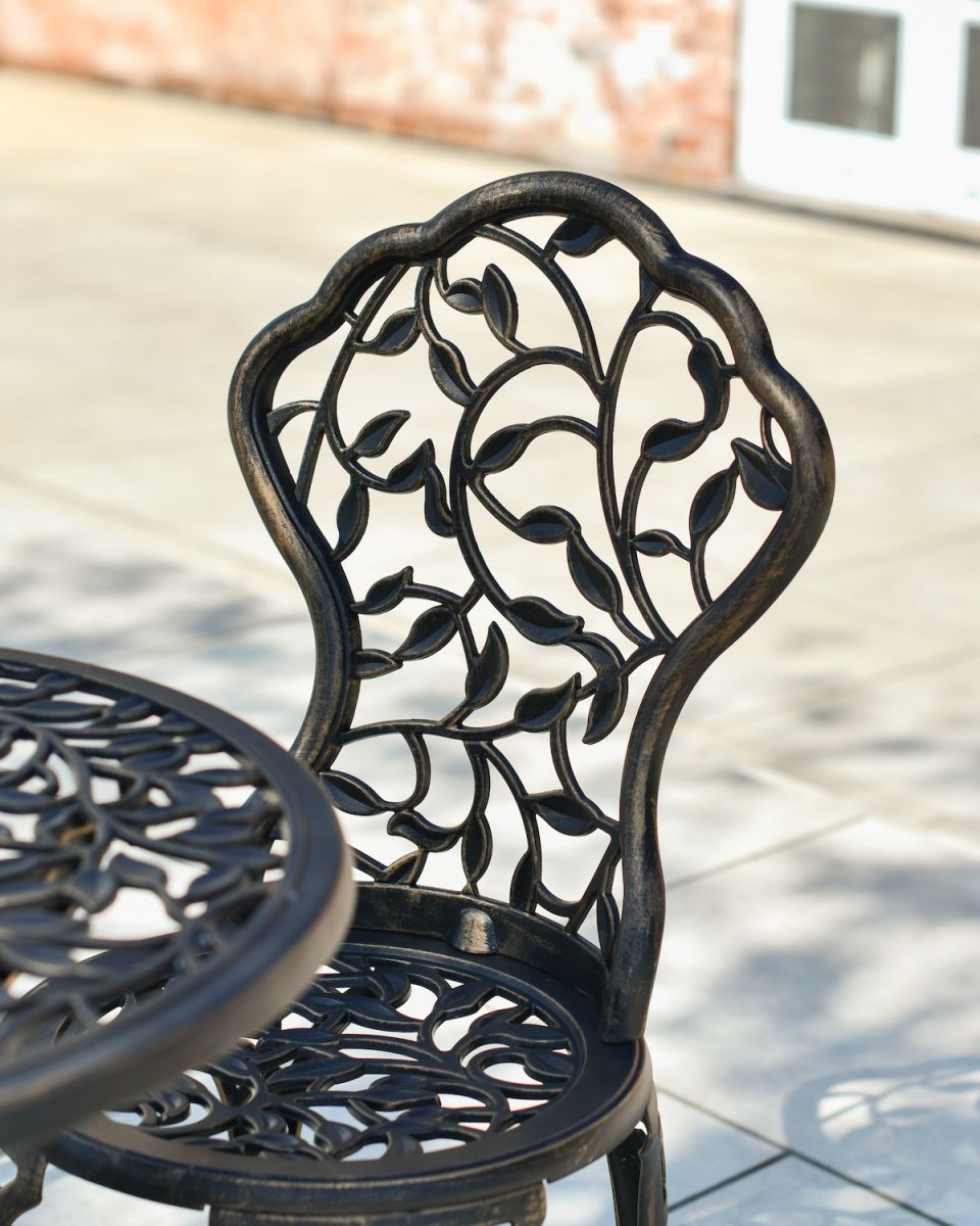 Close up of ornate chair backrest detail on cast aluminium garden furniture set
