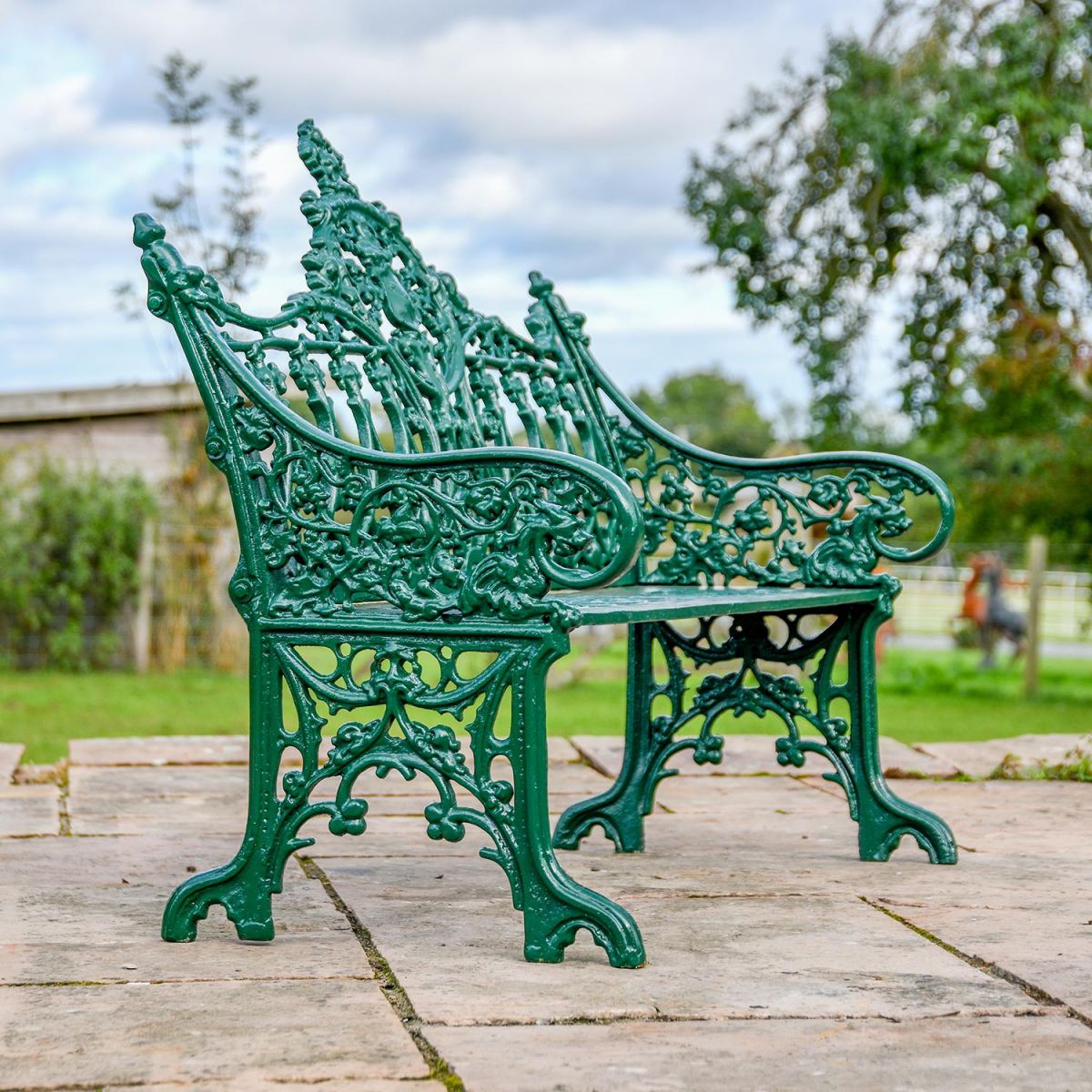 View of the side of the Green Cast Iron Gothic Garden Bench 