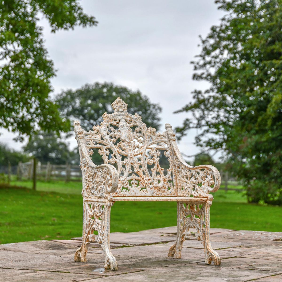 Aged Cream Cast Iron Dog One Seat Park Bench in Use in the Garden