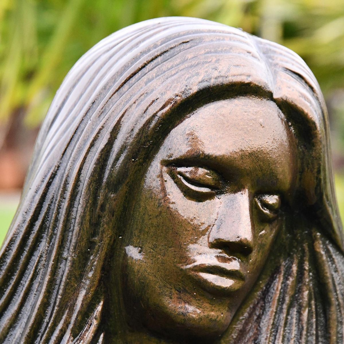 Close-up of the Antique Bronze Face on the Mermaid Garden Sculpture
