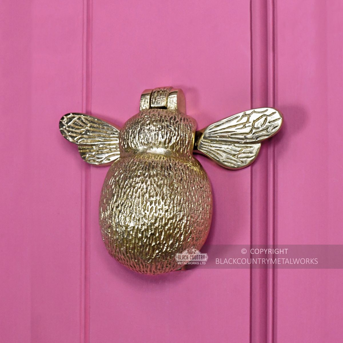 Honey bee door knocker on bright pink door
